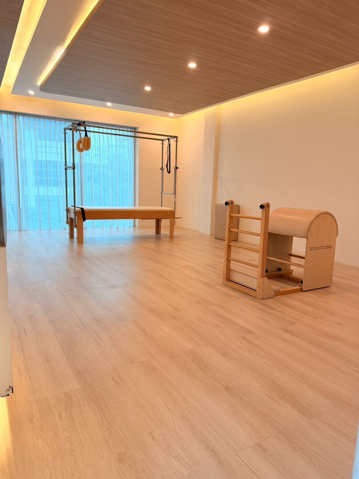 A reformer and ladder barrel in a sunlit corner of the studio